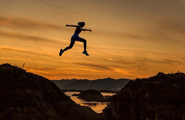 Woman jumping above a lake